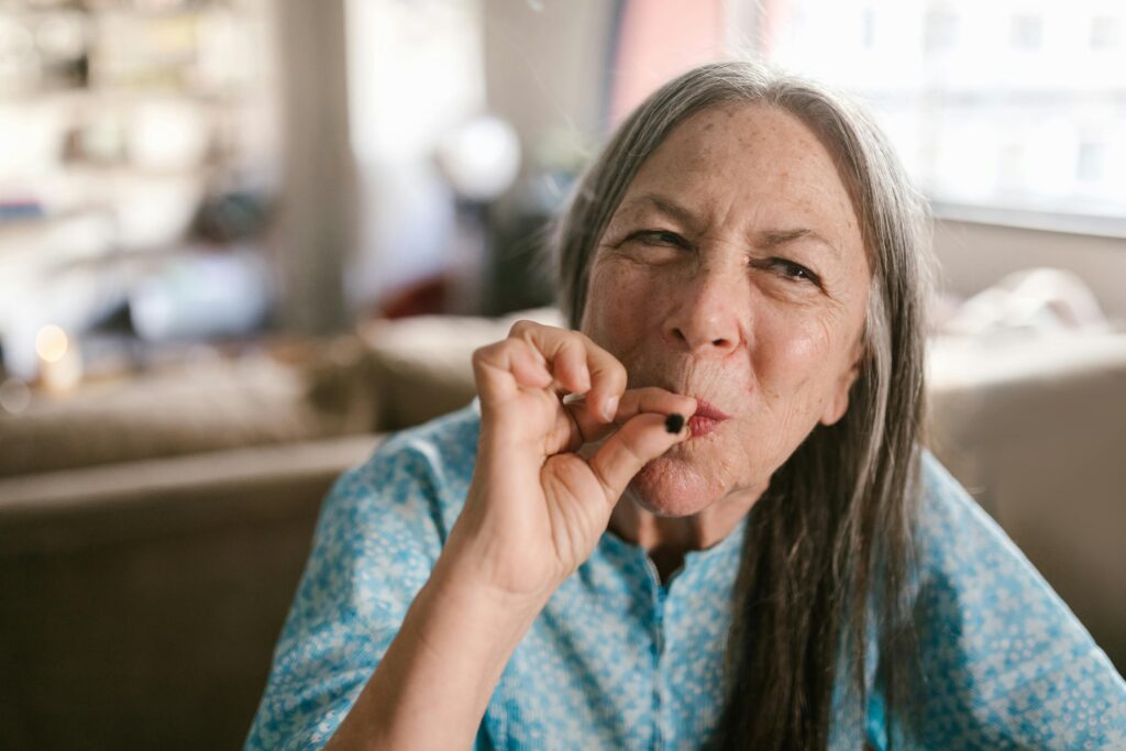 Elderly woman smoking marijuana indoors, illustrating lifestyle and relaxation.